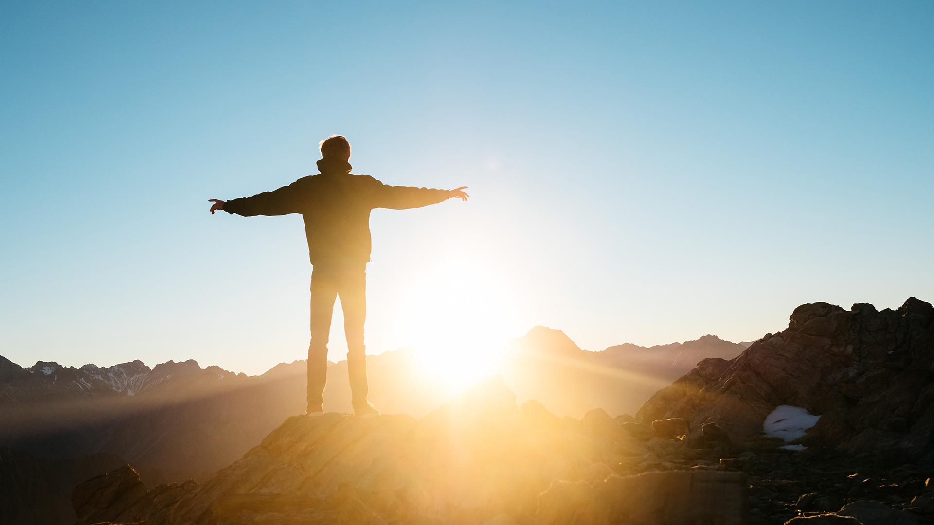 person-standing-on-hill-at-sunrise