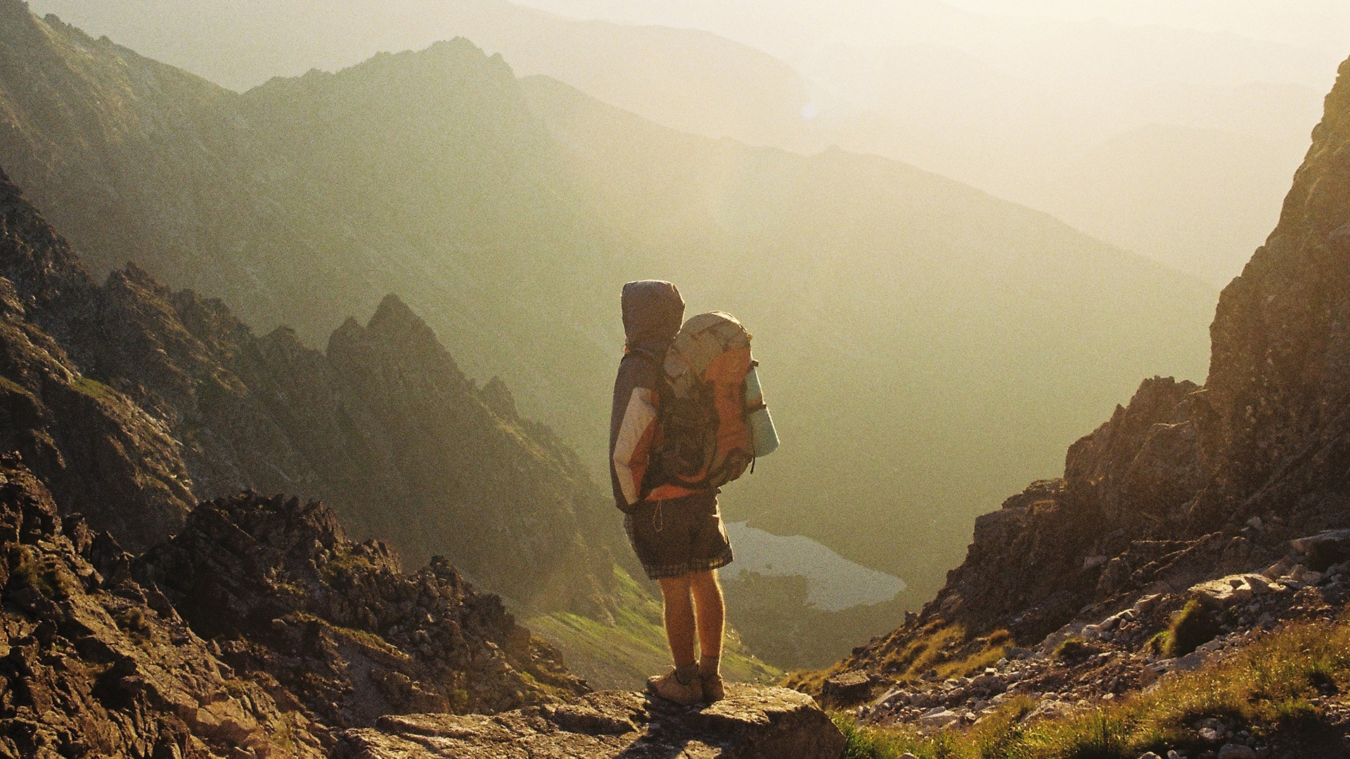 climber-standing-on-rock-near-overlooking-view-of-mountain