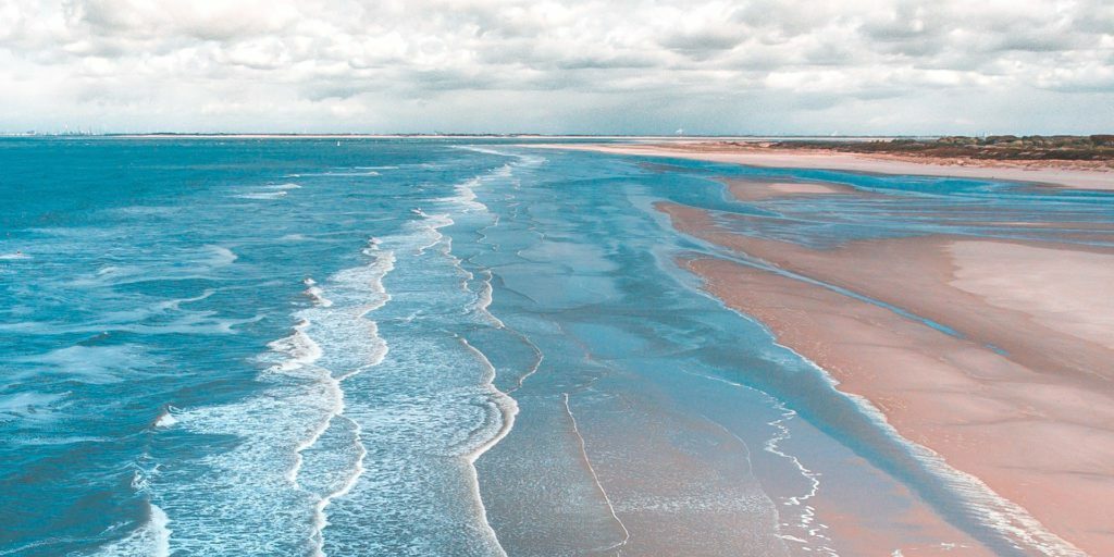 landscape-photo-of-seashore-under-cloudy-sky-during-daytime